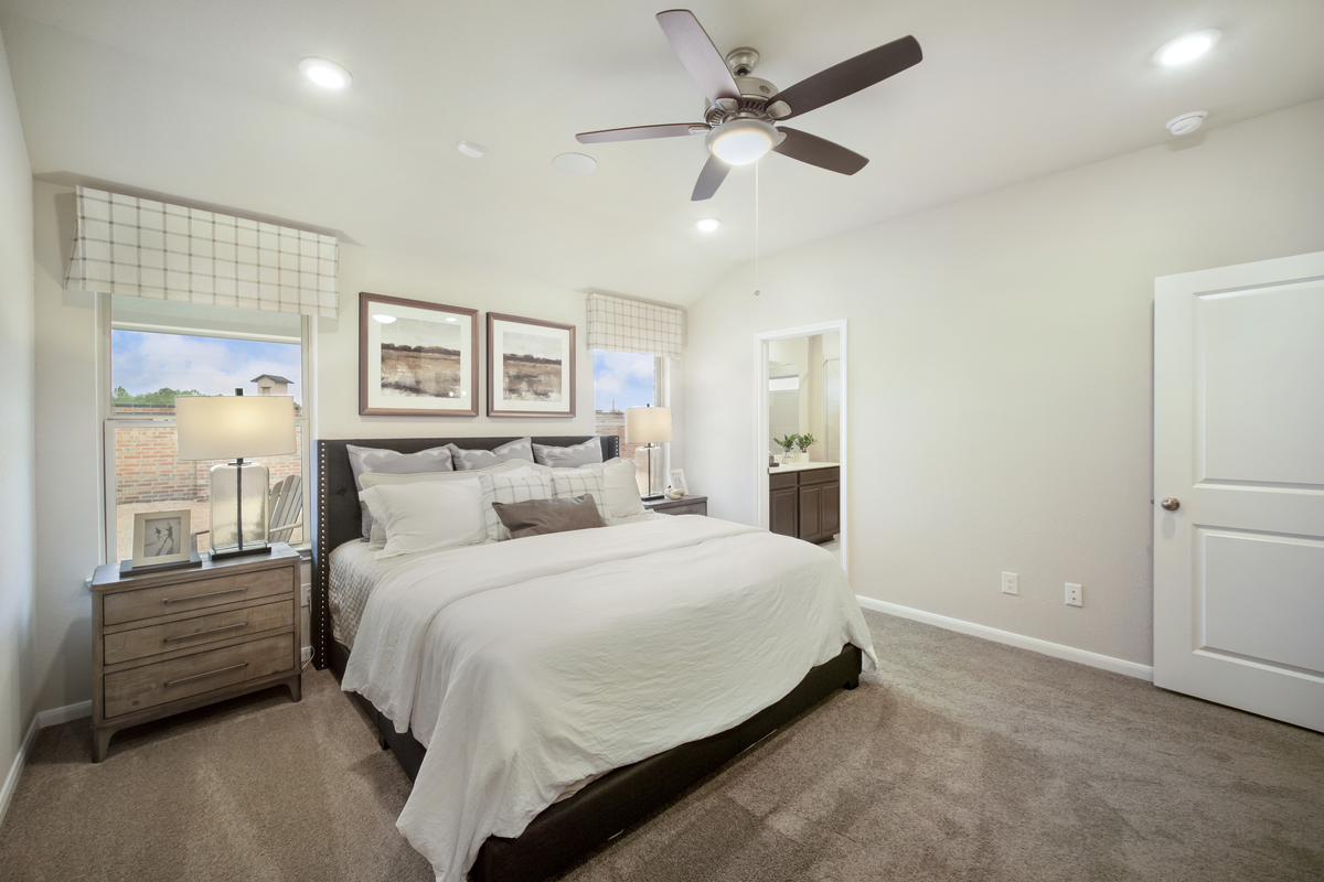 primary bedroom with ceiling fan and natural light