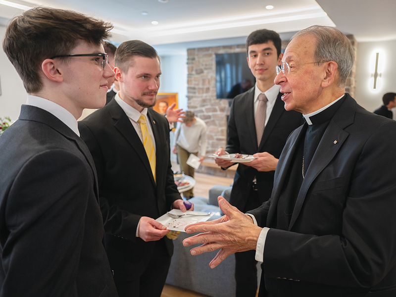 Supreme Chaplain Archbishop William Lori speaks with seminarians at the dedication of the McGivney House of Formation