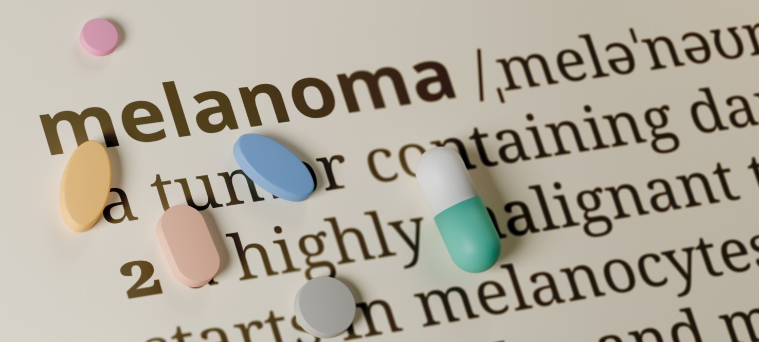 page with definition of melanoma with various pills sitting on top