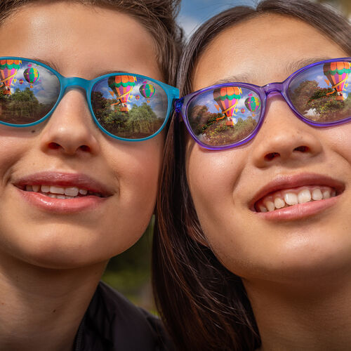 Two kids wearing reflective HOYA MiYOSMART sun spectacle lenses