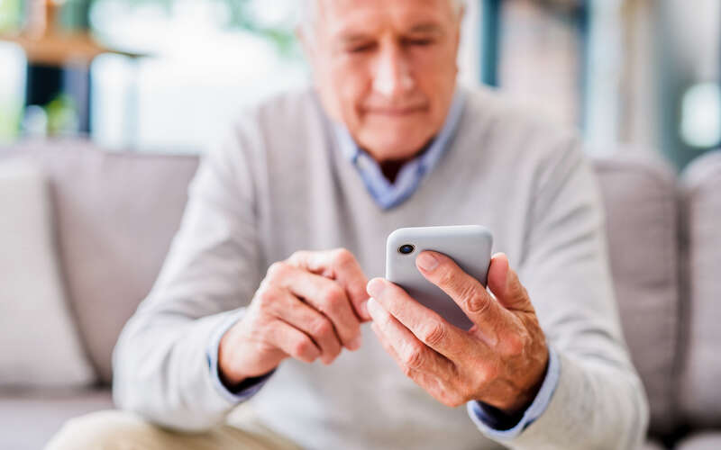 man sitting on couch on cell phone