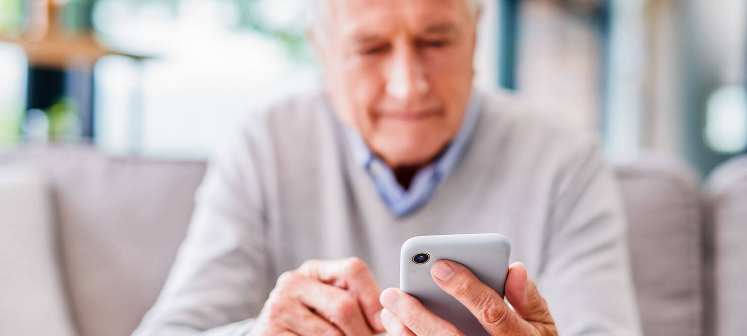 man sitting on couch on cell phone