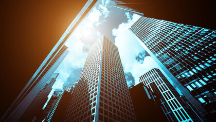 Bottom up view of a modern office building against a sunny sky