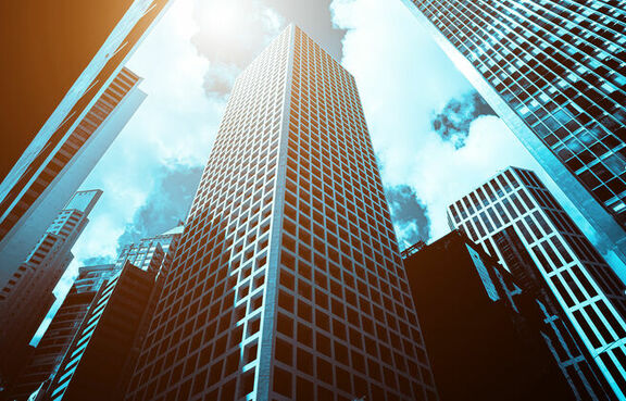 Bottom up view of a modern office building against a sunny sky