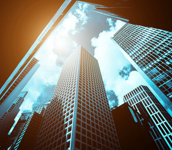 Bottom up view of a modern office building against a sunny sky