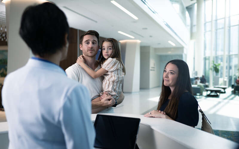 Young family checks in to appointment at front desk