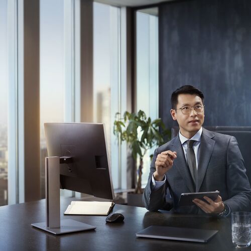 Man in suit behind desk, wearing HOYA MySelf Profile glasses