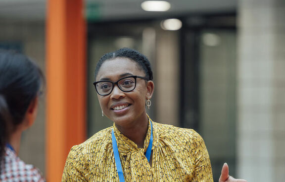 Two women at a table talking over a clipboard