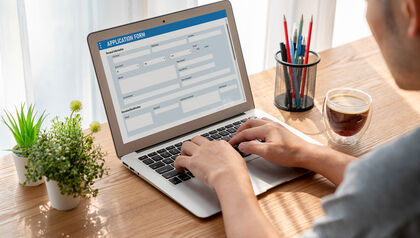 Man filling out an online job application on a laptop at a desk