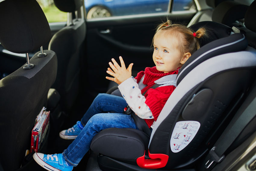 5-letna deklica sedi v vozilu pripeta v otroški avtosedež.