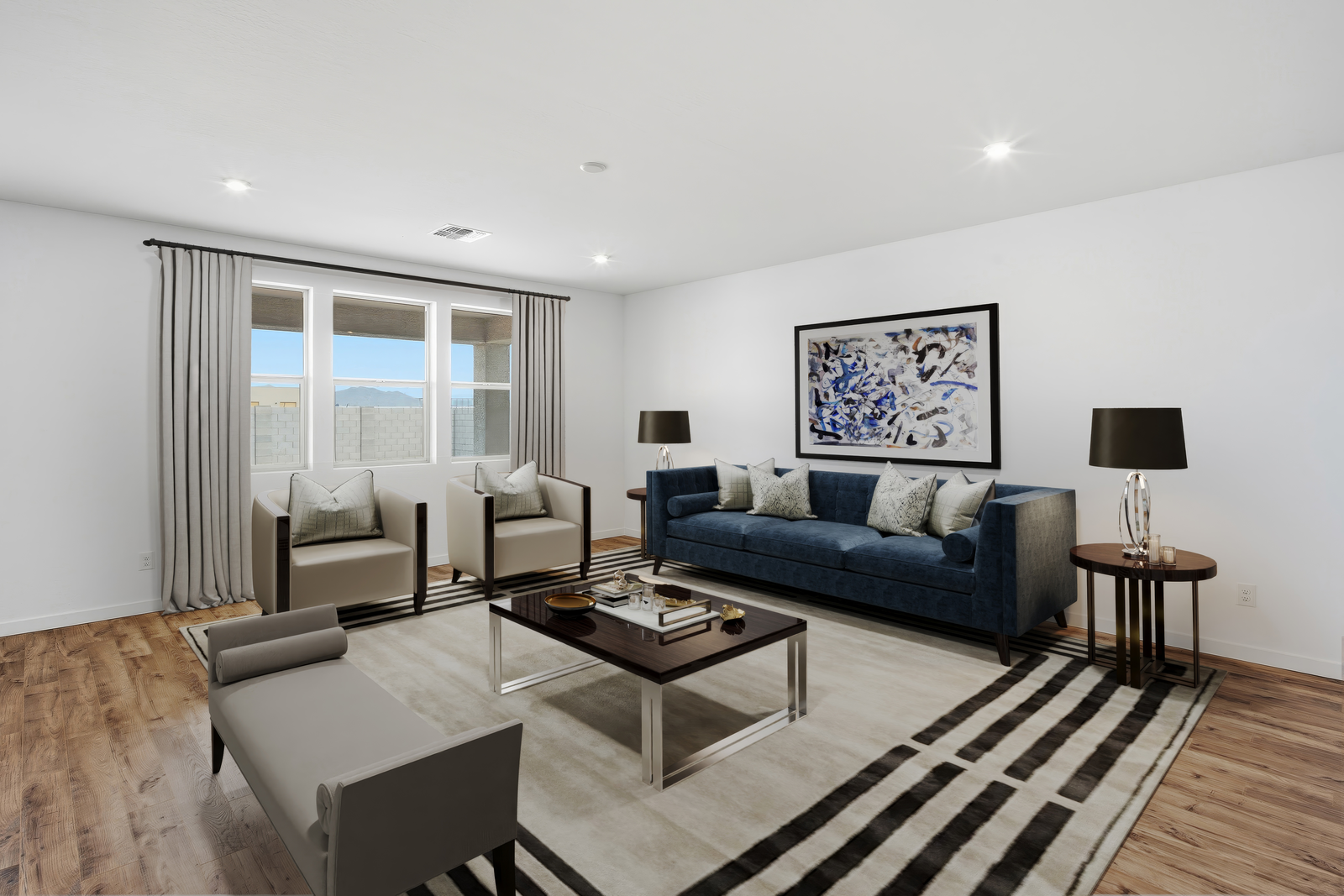 open-concept space with a large navy-blue couch, brown coffee table, and grey accent chairs
