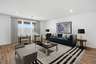 open-concept space with a large navy-blue couch, brown coffee table, and grey accent chairs