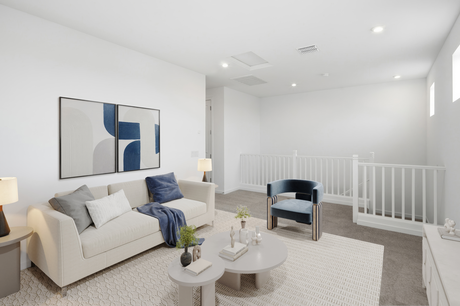 open-concept space with a large white couch, white coffee table, and blue accent chair