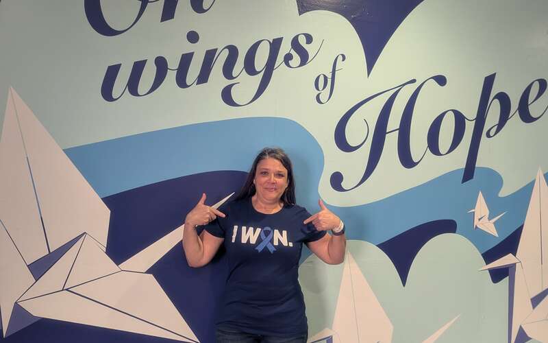 Karen in front of a mural at Moffitt