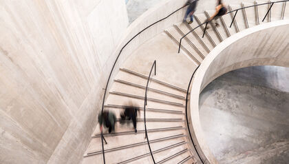 Blurred images of people walking down a large staircase