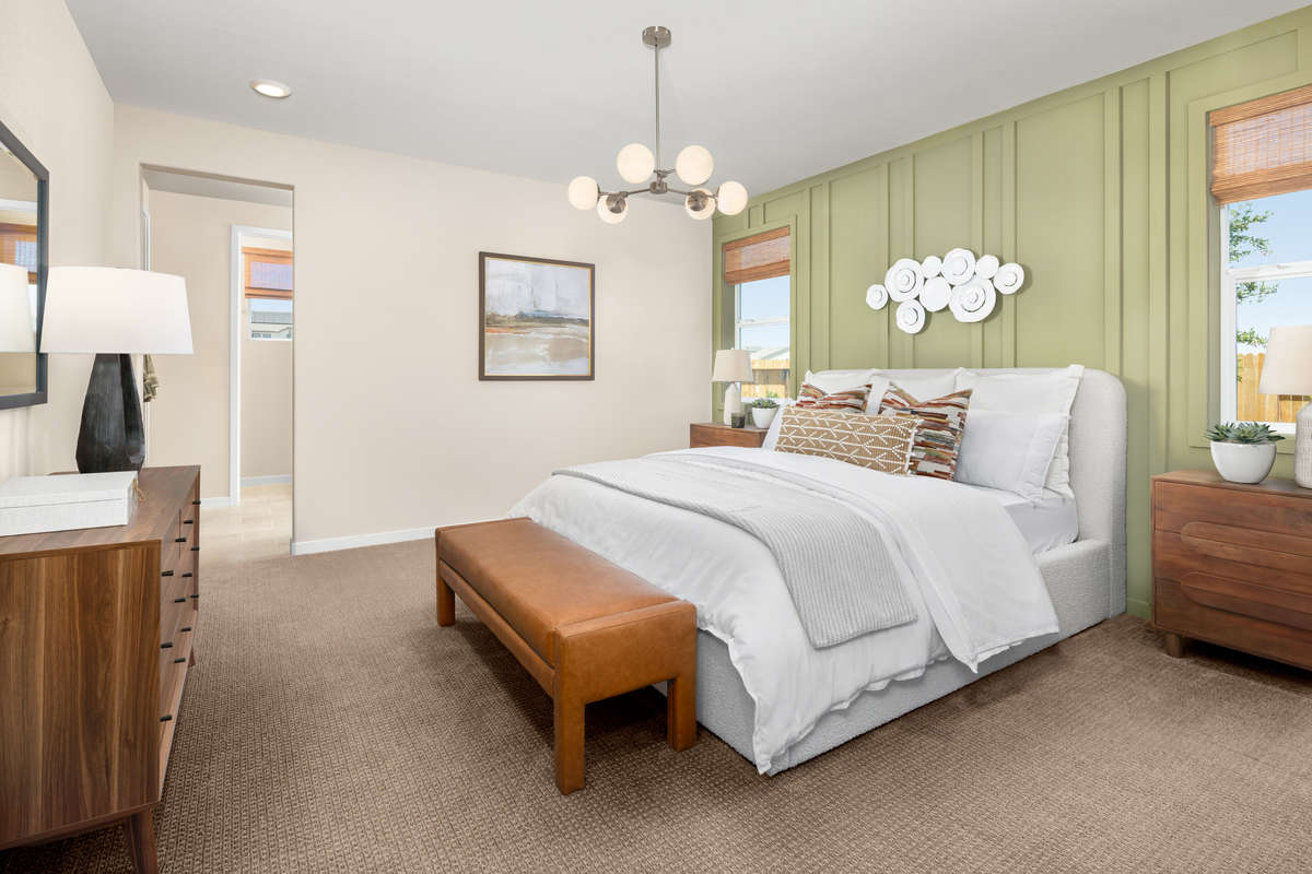 bedroom with sage green accent wall behind bed