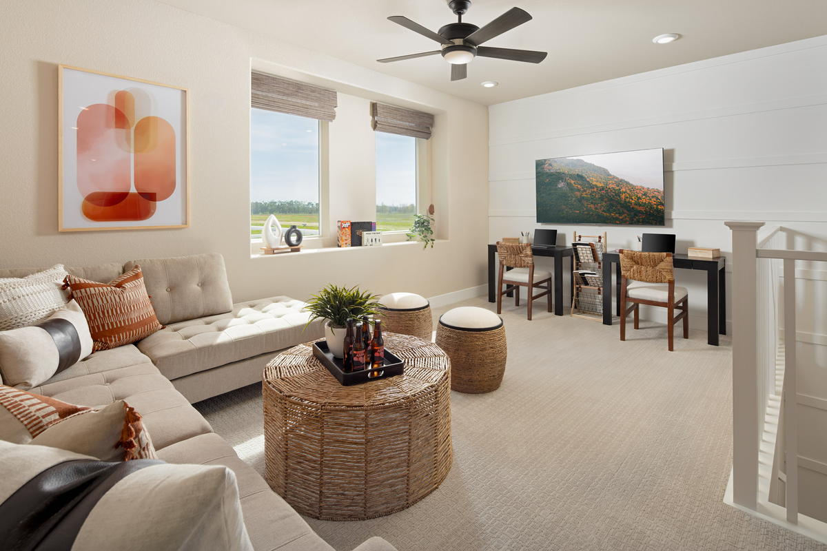loft with two desks, windows, and sectional