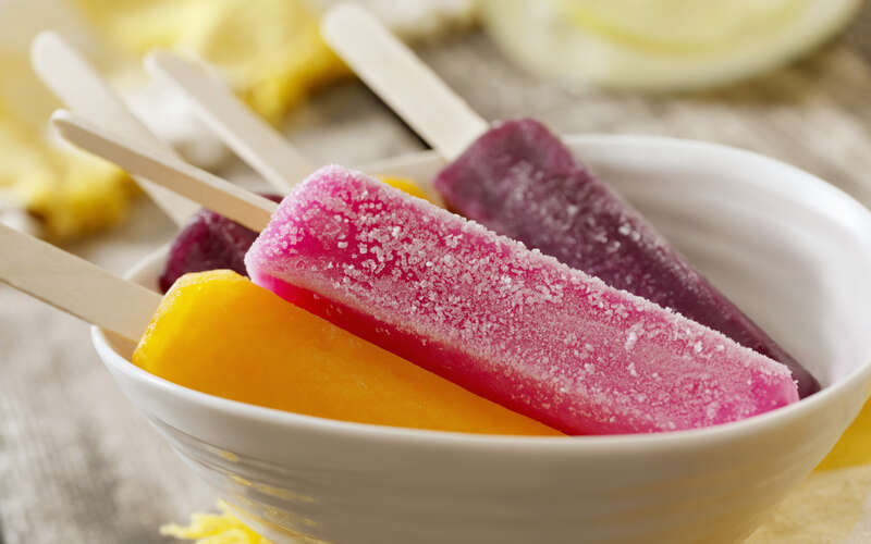 cherry, grape and orange popsicles at a picnic 