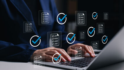 Professional using laptop with approved files check marks