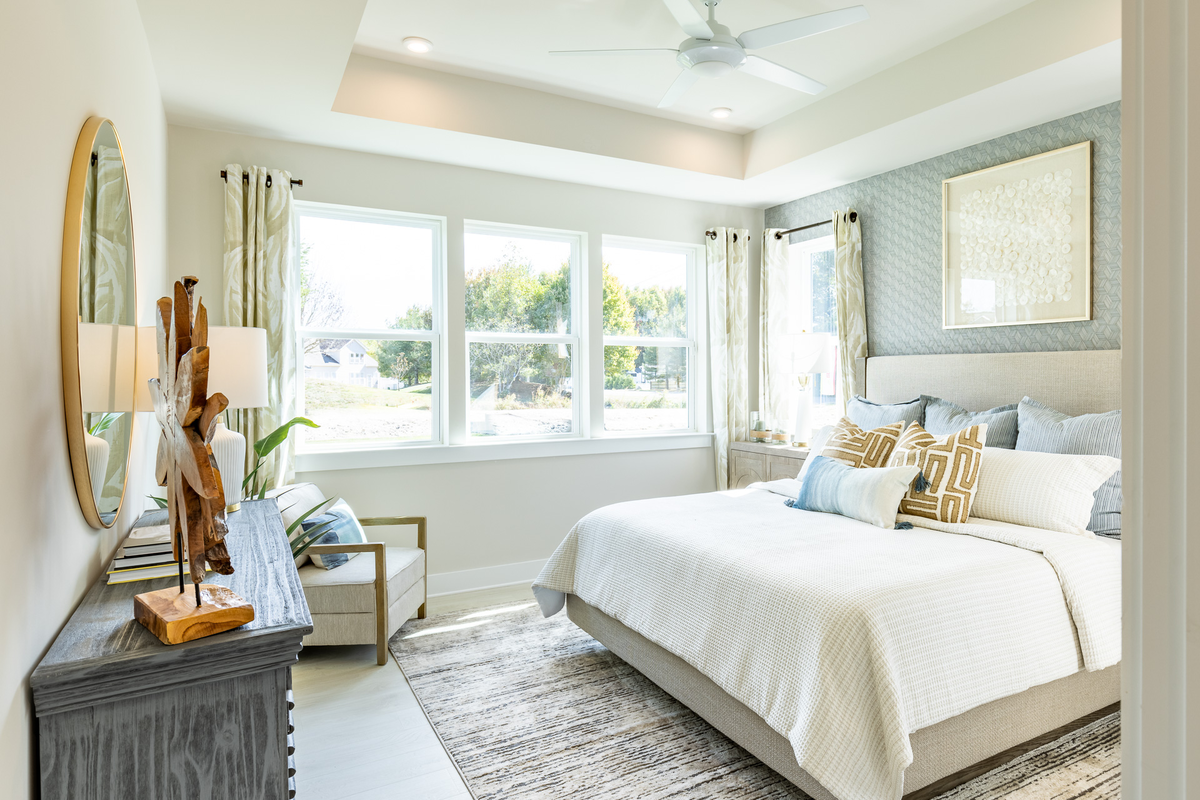 primary suite with a box ceiling and a king bed