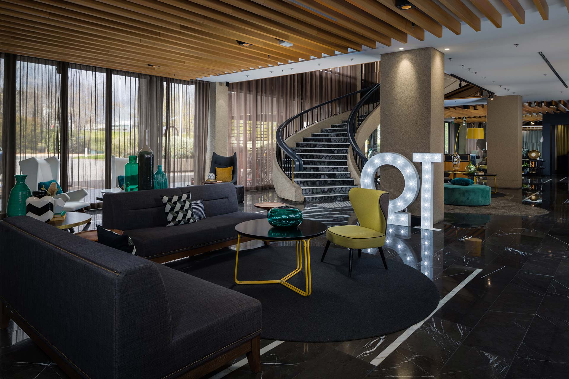 image of QT Hotel Lobby with couches, pillows and large light up QT sign