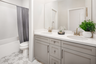 bathroom with dual sinks and tile floors
