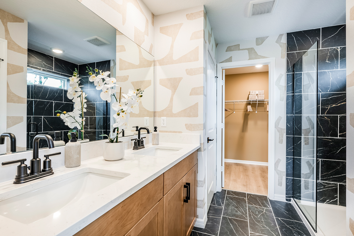 primary bathroom with black tile flooring