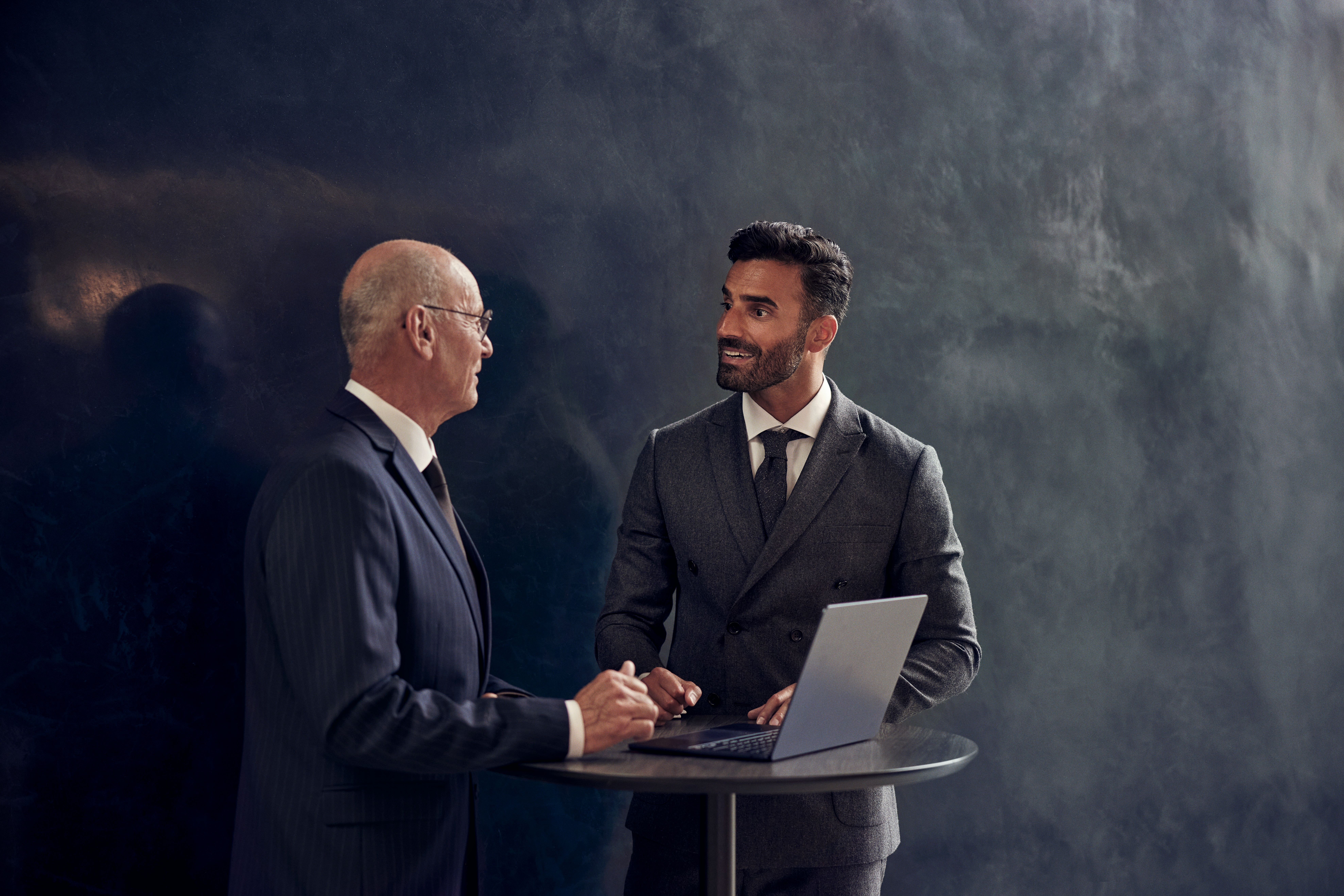 Zwei Menschen im Gespräch, um einen Tisch herum sitzend.