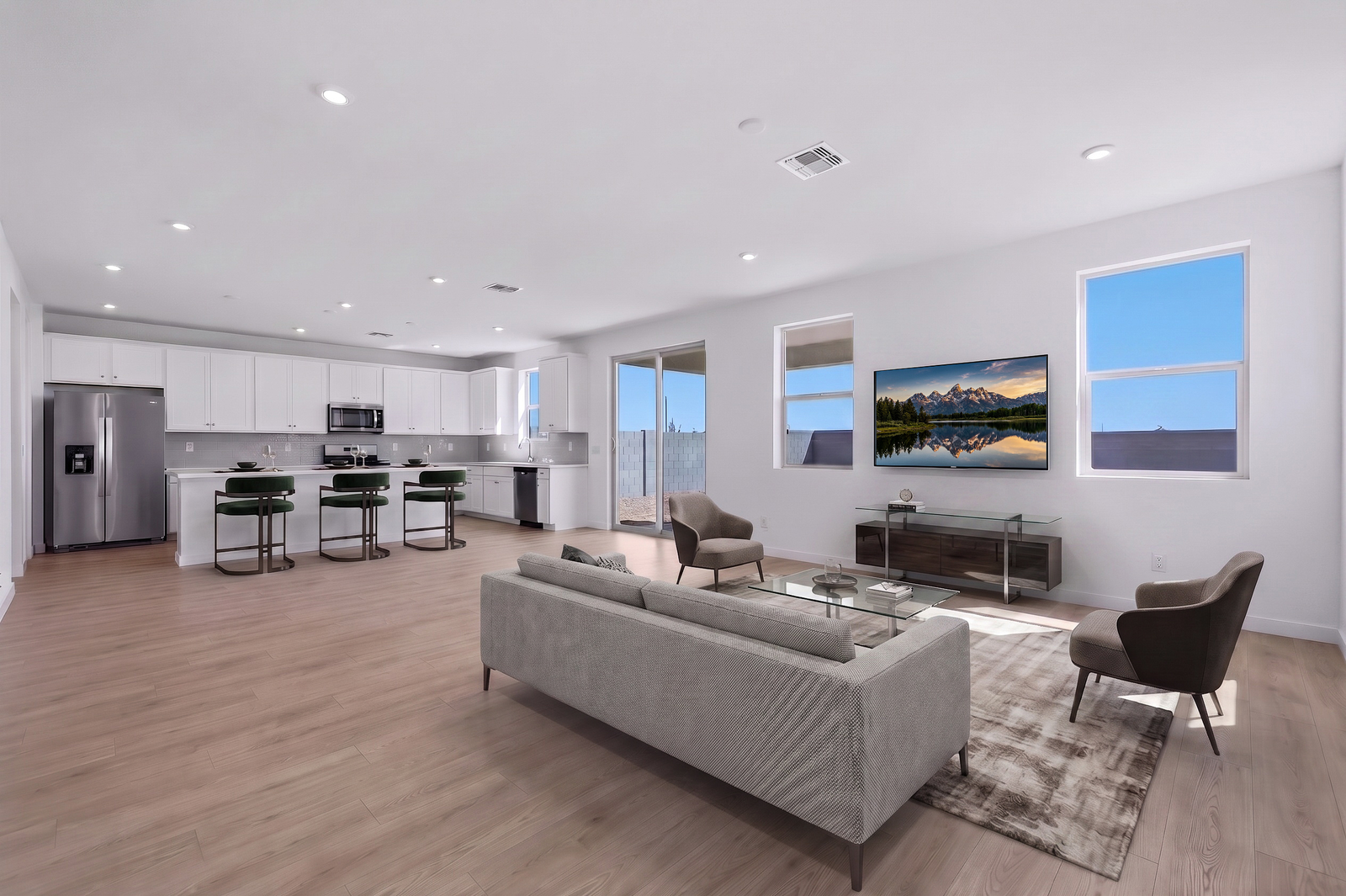 open-concept space with a large grey couch, glass coffee table, and brown rug
