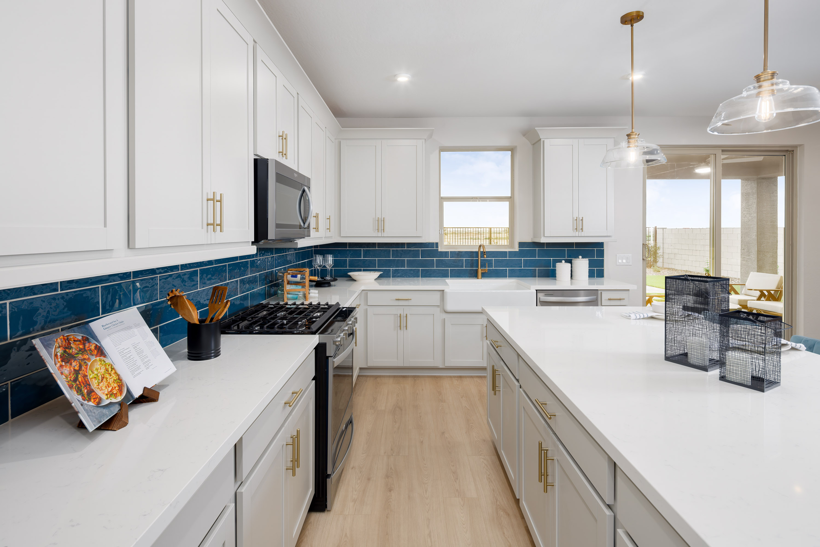kitchen with white cabinets, quartz countertops, and teal tile backsplash