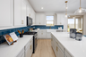 kitchen with white cabinets, quartz countertops, and teal tile backsplash