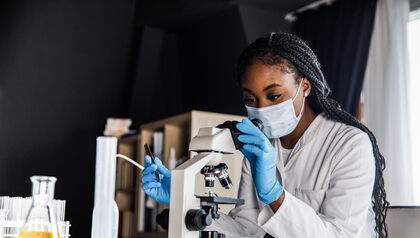 Female scientist looking at samples through a microscope