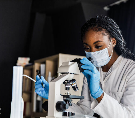 Female scientist looking at samples through a microscope
