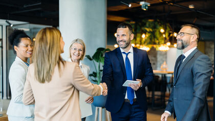 Business professionals welcoming a new colleague