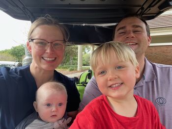 Family takes photo in golf cart
