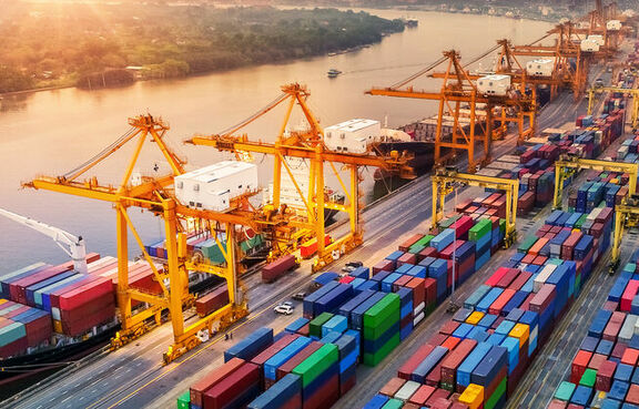 Shipping yard full of ships being loaded at sunset