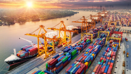 Shipping yard full of ships being loaded at sunset