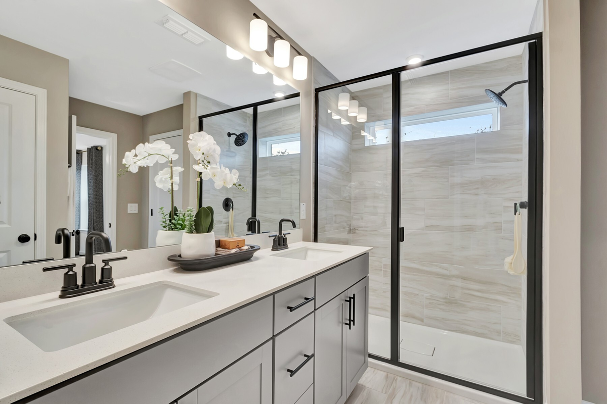 bathroom with large shower and two sinks