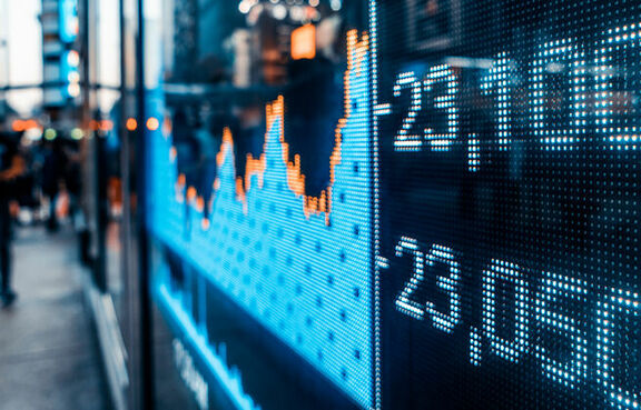Display showing stock prices and line graph on a busy street