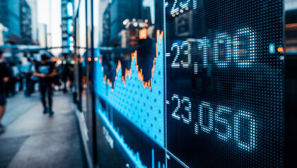 Display showing stock prices and line graph on a busy street