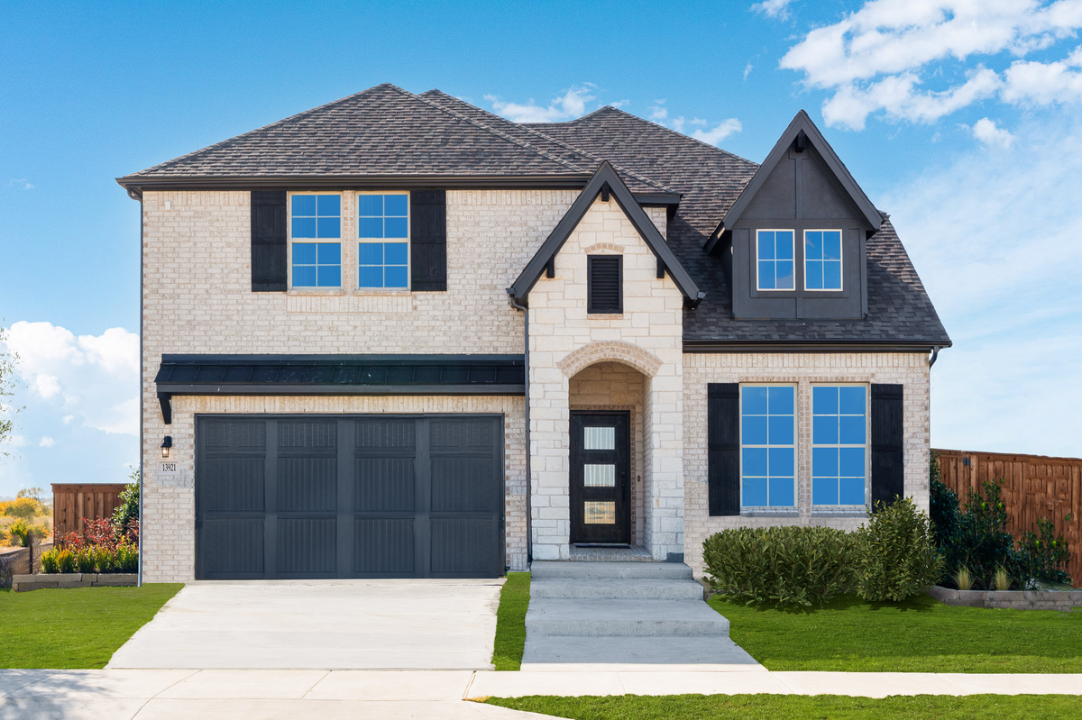 brick and stone exterior with tree in front yard