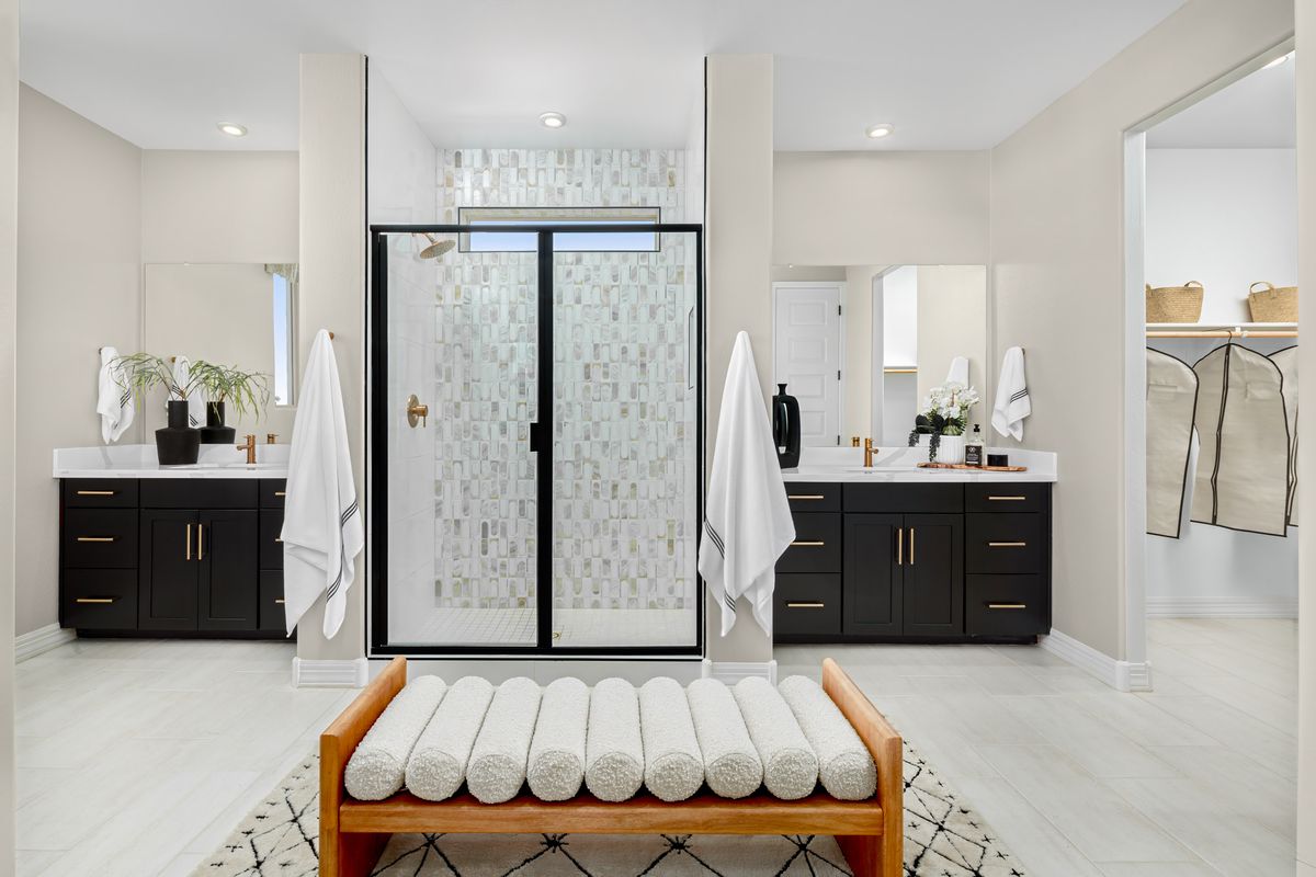 large bathroom with walk-in shower and vanities