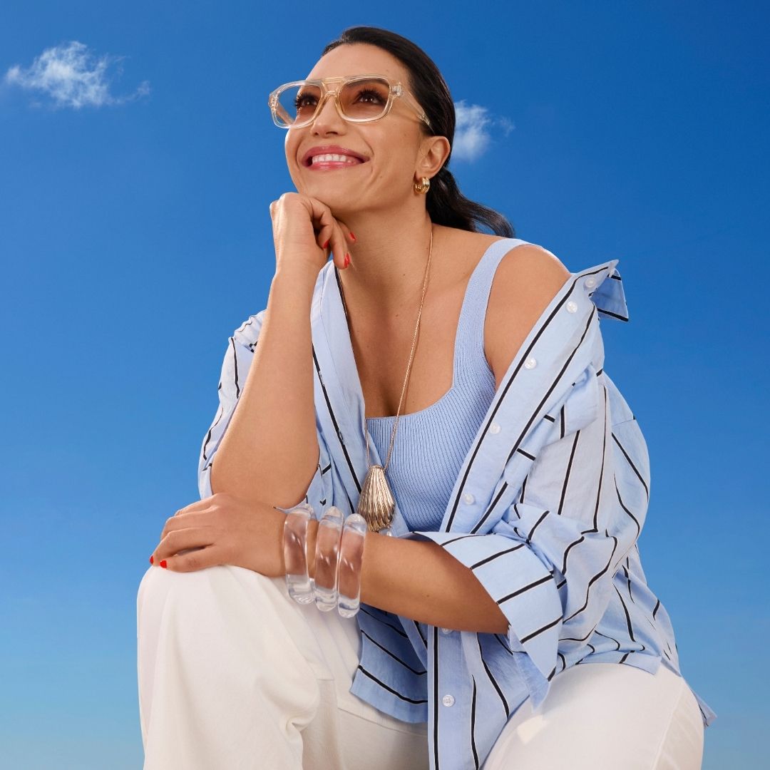 Image of a woman smiling, wearing sunglasses and dressed for spring.