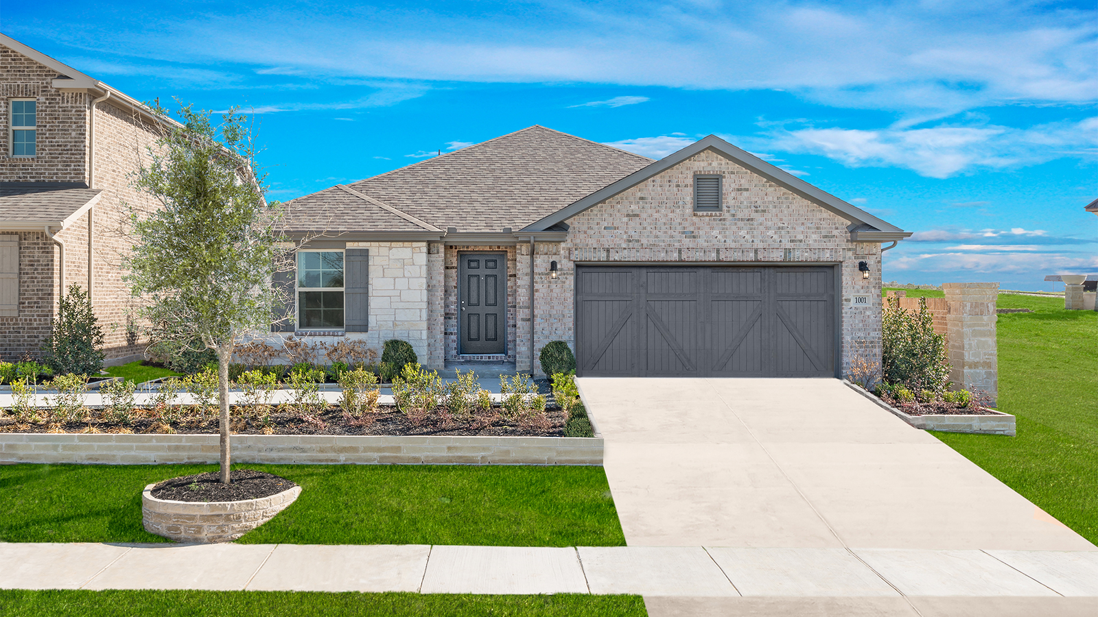 brick exterior with small tree in front yard