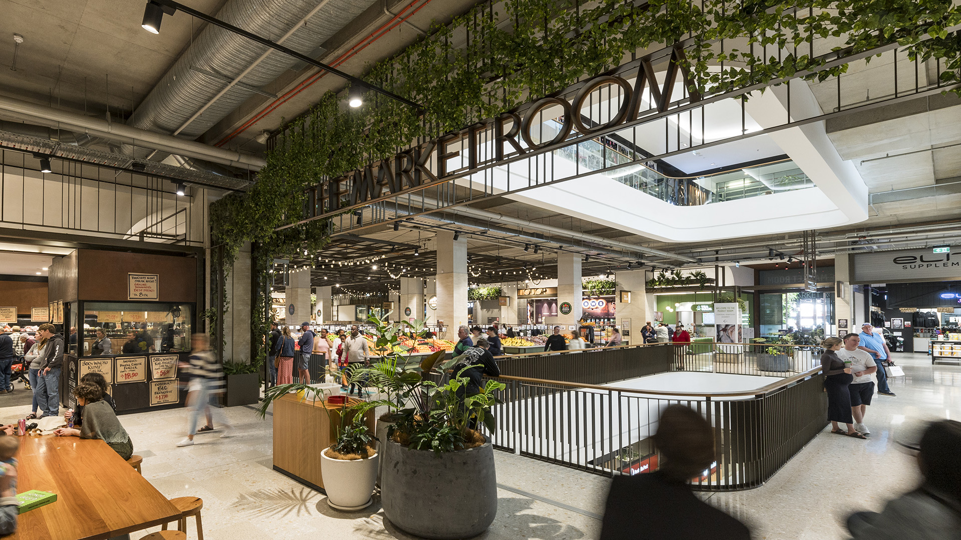 Image of market room in shopping centre with customers eating and walking around