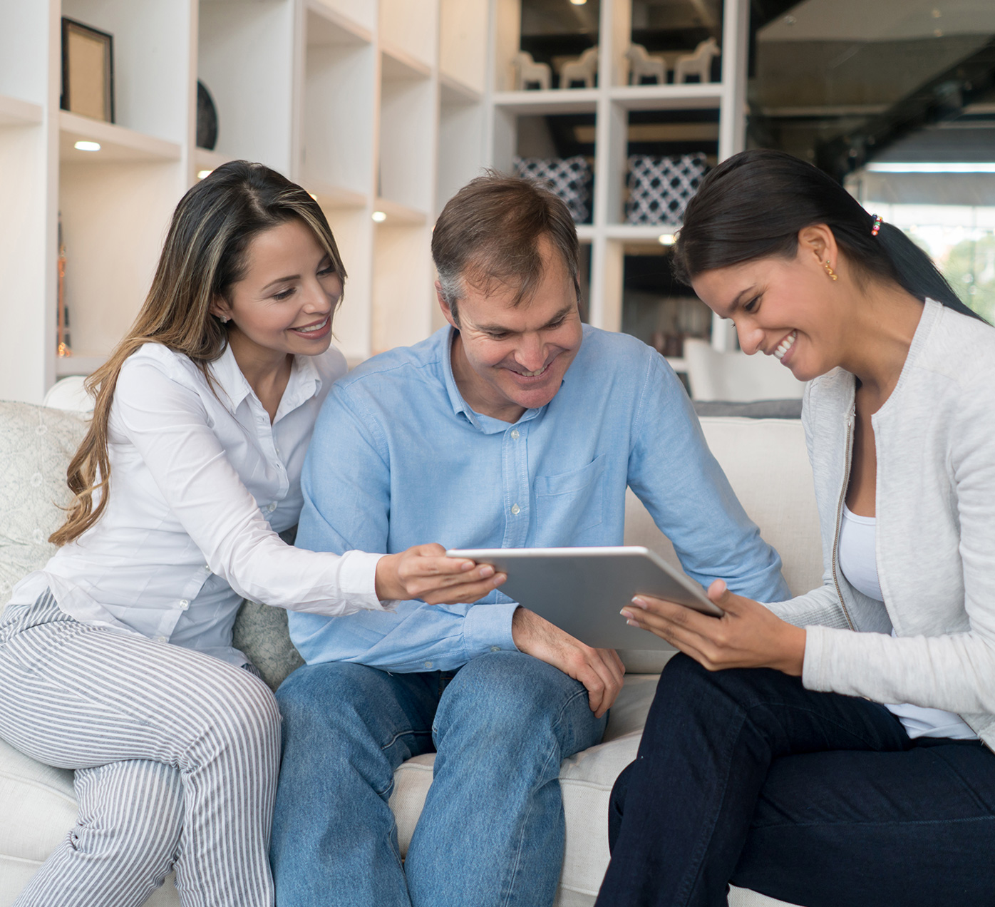 Three people looking at an iPad.