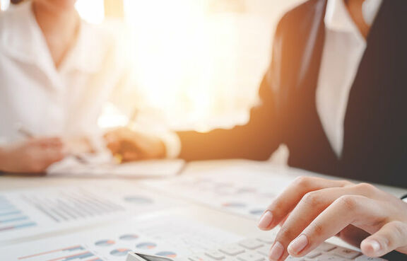 Two businesspeople calculating taxes at a desk