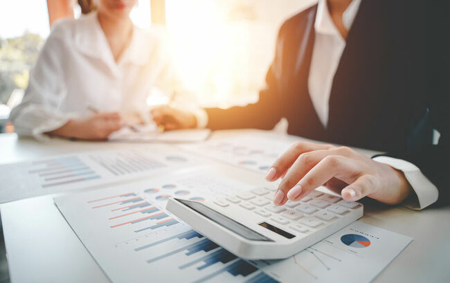 Two businesspeople calculating taxes at a desk