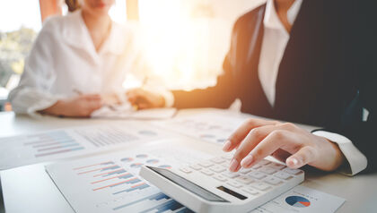 Two businesspeople calculating taxes at a desk