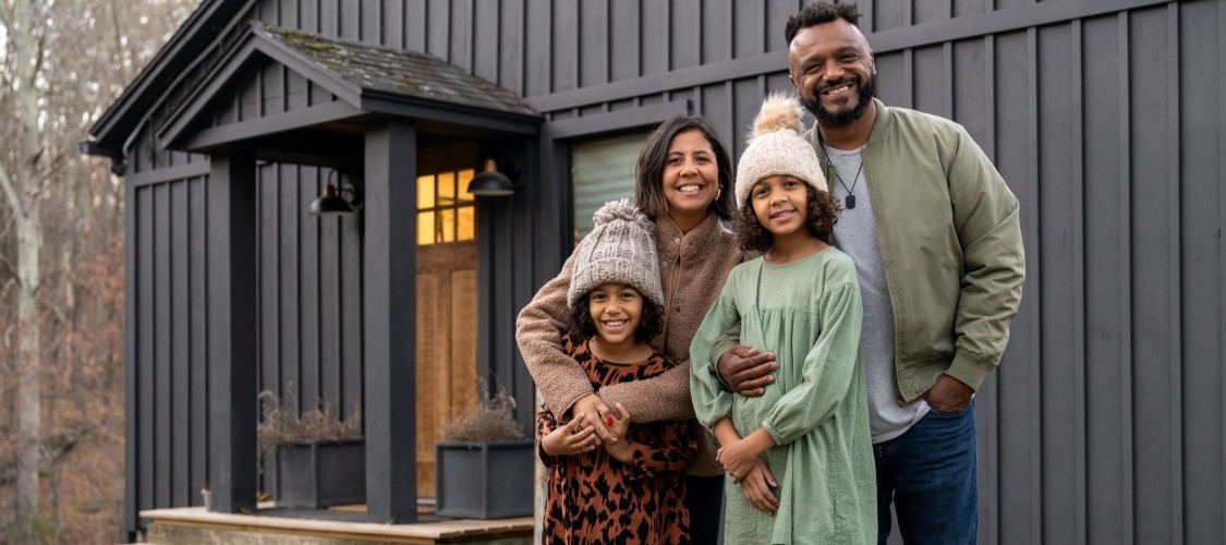 A happy family in front of their new home